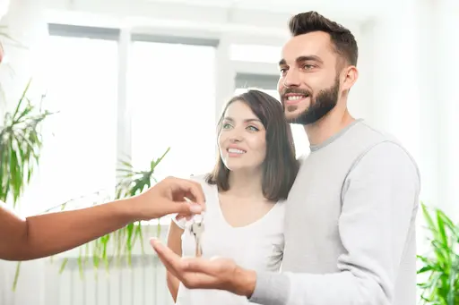couple souriant recevant une clé
