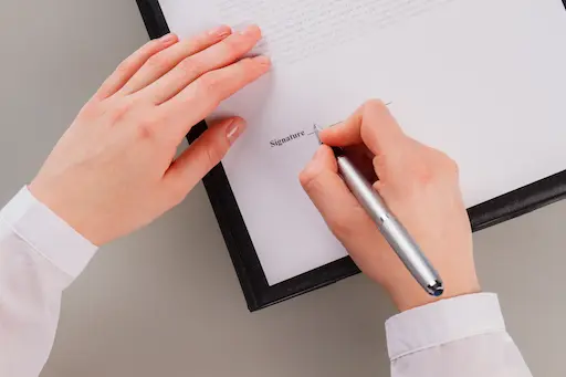 2 mains avec un stylo prêt à signer un document