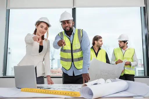 artisan et chef de chantier pointant du doigt l'internaute