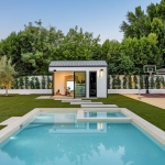 Jardin avec piscine, terrain de sport et maison.