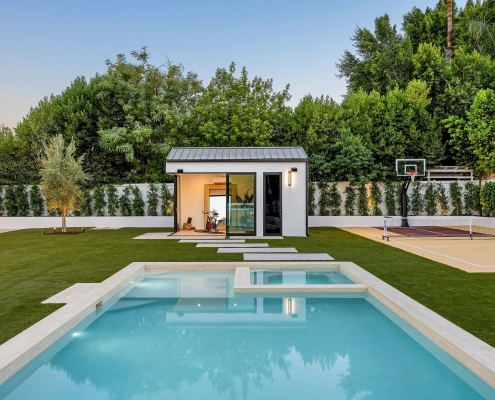 Jardin avec piscine, terrain de sport et maison.