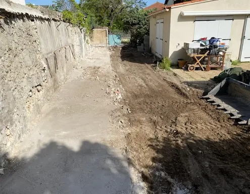 Allée en terre entre deux murs.