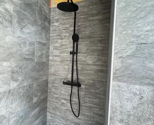 Douche moderne à carrelage gris.