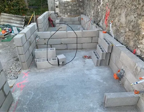 Construction de murs en parpaings sur chantier.