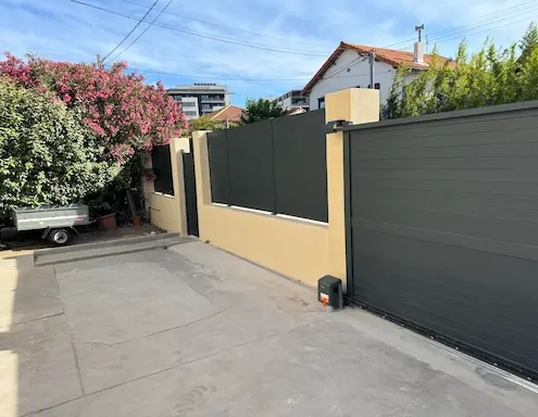 Entrée de garage moderne avec portail fermé.