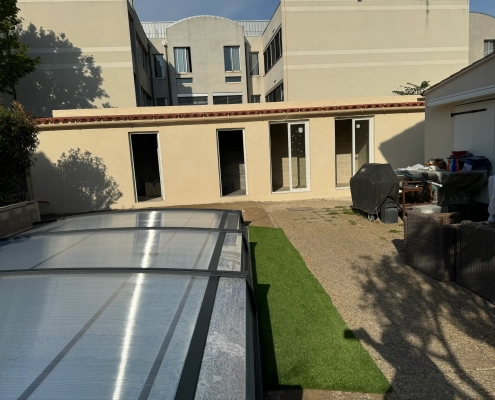 Cour avec abri et mobilier extérieur.
