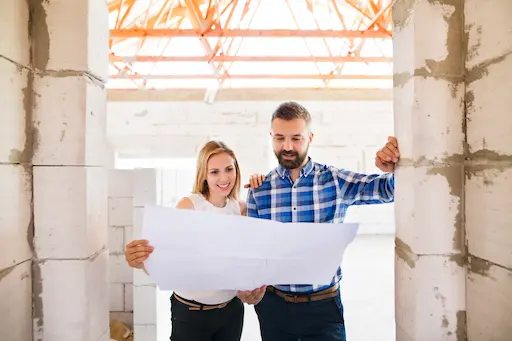 Couple examinant des plans de construction.