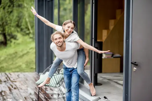 courtage pour construction neuve innova solution couple souriant sur une terrasse de maison