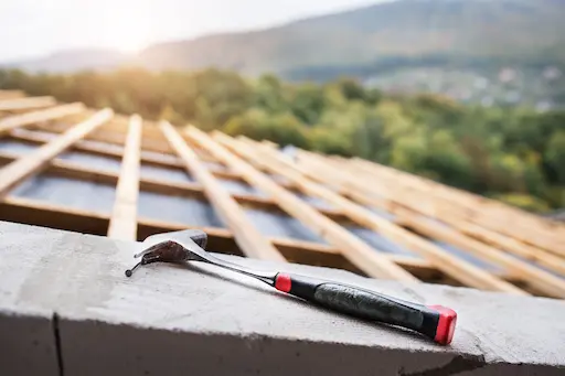 Toit en construction avec marteau posé.