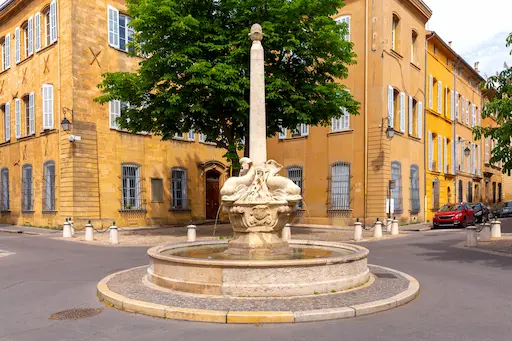 Fontaine en pierre dans une rue pavée.