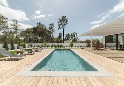 Piscine extérieure entourée de chaises longues.