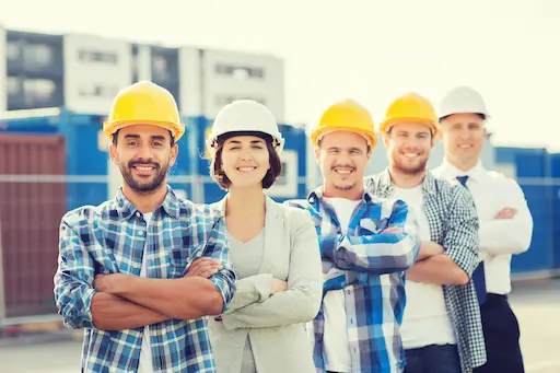 Groupe de travailleurs du bâtiment souriants.