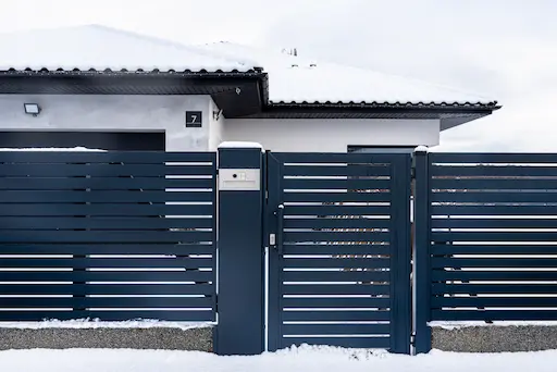 Maison moderne avec grande clôture en métal.