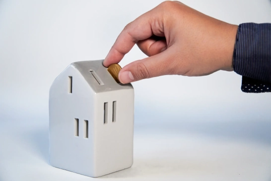 innova solution le guide complet des aides à la rénovation Énergétique Main insère pièce dans tirelire maison.