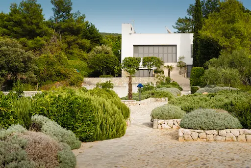 Maison moderne entourée de verdure et jardin.