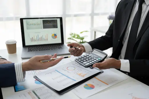 maitrisez votre budget construction avec votre courtier innova solution Réunion d'affaires avec graphiques et calculatrice.
