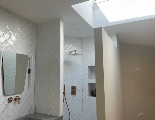 Salle de bain moderne avec carrelage blanc.