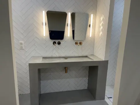 Salle de bain moderne avec doubles miroirs éclairés.