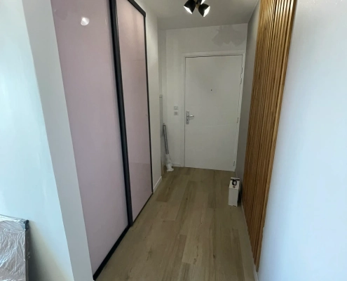 Couloir avec portes coulissantes et lumière au plafond.