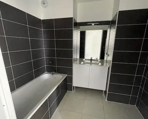 Salle de bain moderne avec baignoire et lavabo.