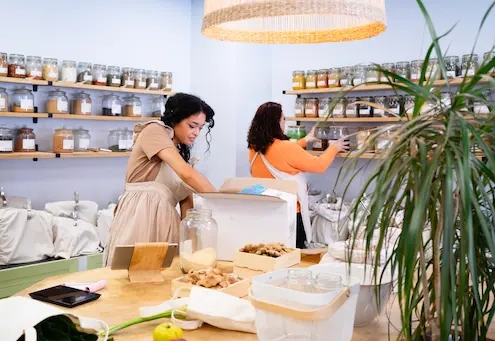 Femmes organisant des bocaux dans une boutique.