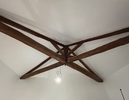 Plafond avec poutres en bois apparentes.