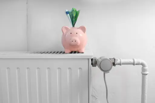 tirelire rose en forme de cochon sur chauffage mural