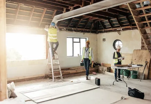 intérieur d'une maison sous les combles en travaux avec des ouvriers