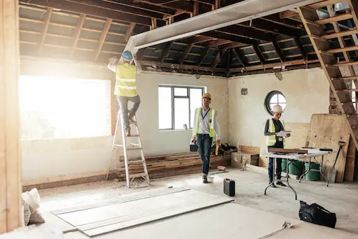 Travailleurs rénovant une maison en construction.